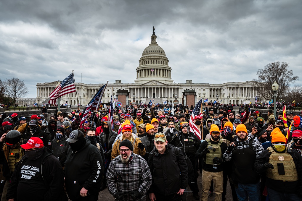 Pro-Trump protesters, including Proud Boys leaders Joe Biggs (plaid shirt at bottom center of frame) and Zachary Rehl (MultiCam hat at bottom center of frame,) gather in front of the U.S. Capitol Building on January 6, 2021, in Washington, DC. (Jon Cherry/Getty Images) 