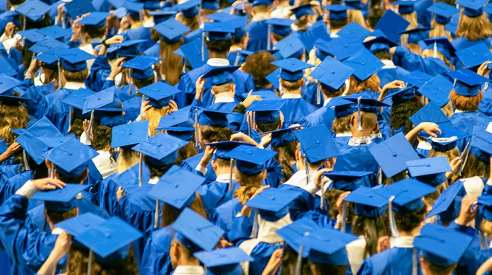 Student audience in their graduation hats and gowns at a graduation ceremony