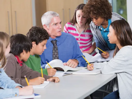 Male Teacher Helping Students in Classroom