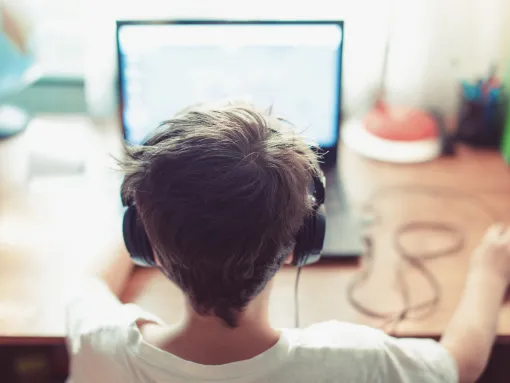 Little gamer kid playing on laptop