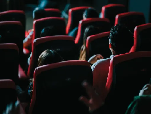 Rear view of audience watching 3D movie in a theater