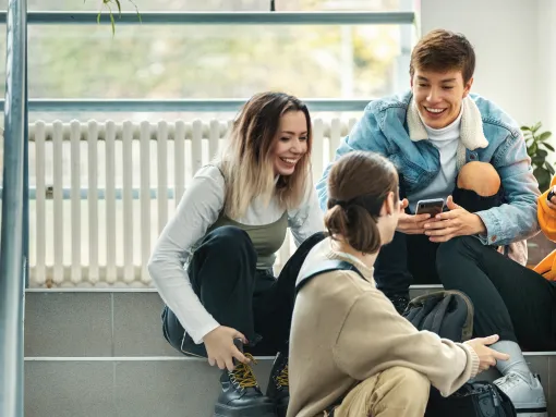 Group of high school students sitting in the hallway laughing