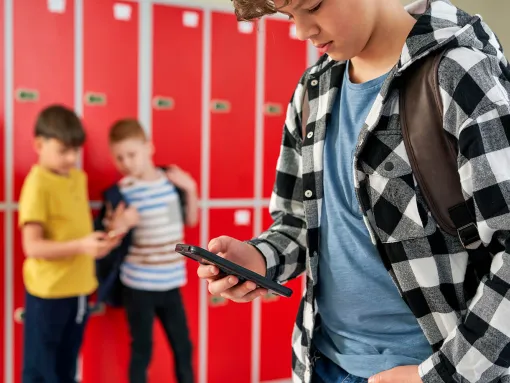 Child texting in school hallway