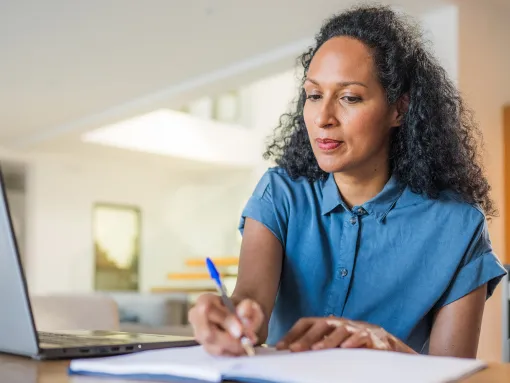 Woman sitting at desk looking at laptop