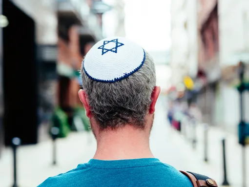 Mid adult Jewish man in his 30s wearing a traditional Jewish skull cap (with star of David design)