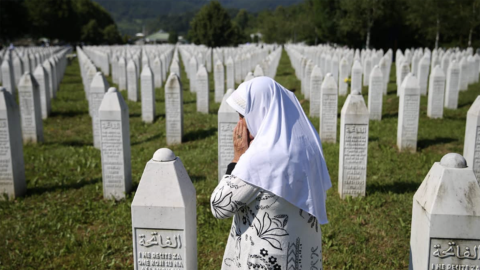 Graveyard in Srebrenica with woman crying